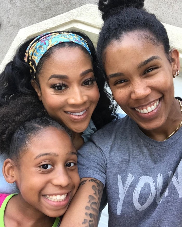Mimi taking a photo with her girlfriend and daughter.